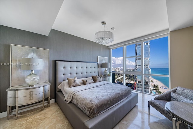 bedroom featuring an inviting chandelier, a wall of windows, and baseboards