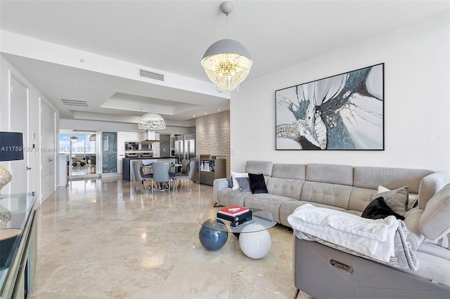 18201 Collins Ave Unit 4404, Sunny Isles Beach, FL 33160 - living room featuring a tray ceiling, a chandelier, and light marble finish floors
