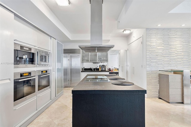 18201 Collins Ave Unit 4404, Sunny Isles Beach, FL 33160 - kitchen with built in appliances, dark countertops, light tile patterned flooring, white cabinets, and island exhaust hood