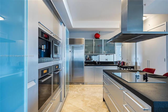 kitchen with white cabinetry, dark countertops, island exhaust hood, and stainless steel appliances