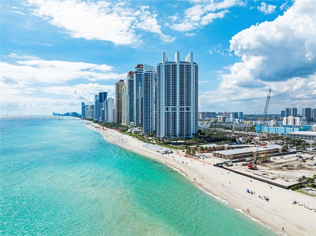 drone / aerial view featuring a city view, a view of the beach, and a water view