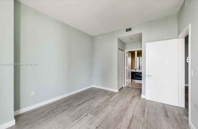 unfurnished bedroom featuring visible vents, baseboards, and wood finished floors