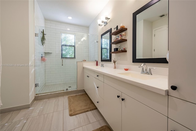 full bathroom with double vanity, visible vents, a stall shower, and a sink