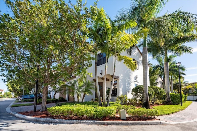 exterior space with decorative driveway, a garage, and stucco siding