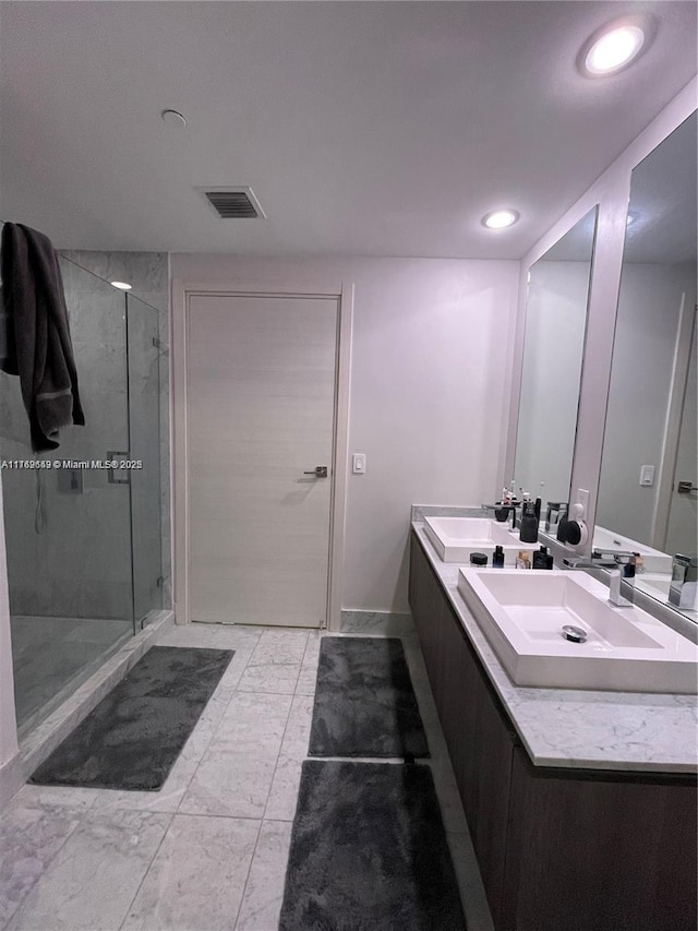 bathroom with a sink, visible vents, and a shower stall