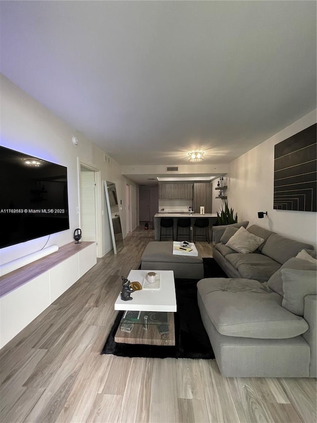 living room featuring light wood-type flooring and visible vents