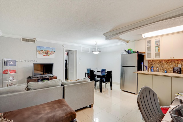 living area featuring crown molding, light tile patterned floors, visible vents, and a textured ceiling