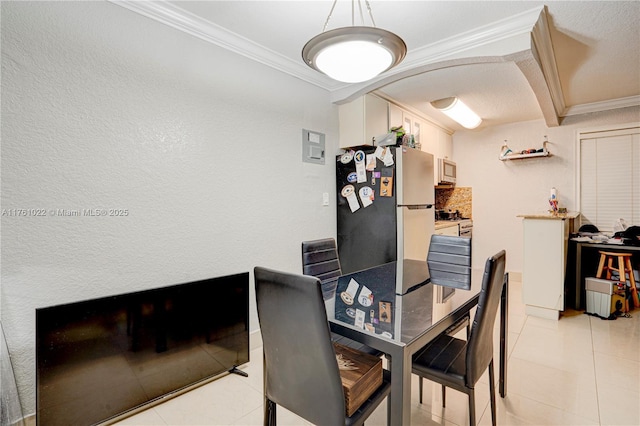 dining space featuring light tile patterned floors, arched walkways, and crown molding