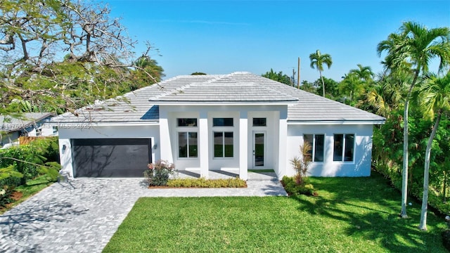 view of front of house with stucco siding, decorative driveway, a front lawn, and an attached garage