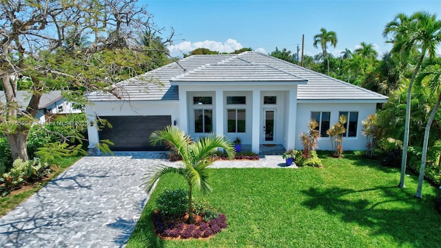 view of front of home featuring a garage, stucco siding, decorative driveway, and a front yard