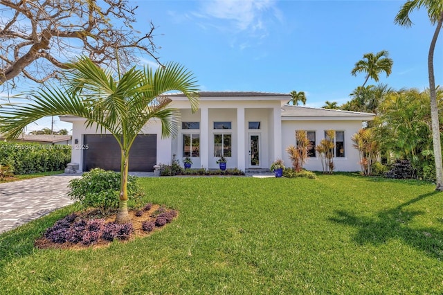 view of front of home featuring stucco siding, a front lawn, an attached garage, and driveway