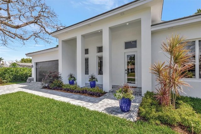 4440 NE 15th Ter, Oakland Park, FL 33334 - property entrance featuring a lawn, decorative driveway, a garage, and stucco siding