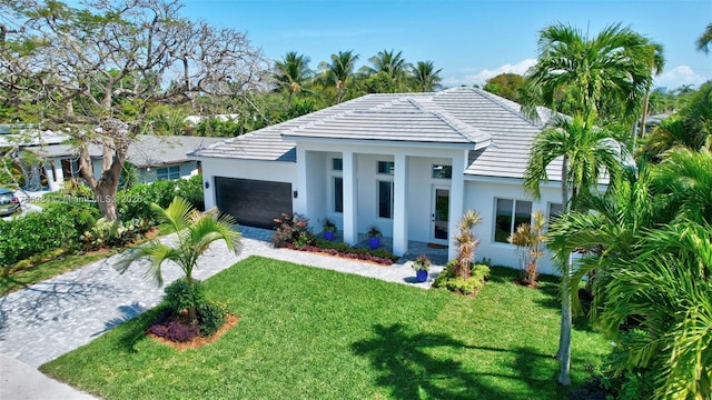 4440 NE 15th Ter, Oakland Park, FL 33334 - view of front of property with a front yard, decorative driveway, a garage, and stucco siding