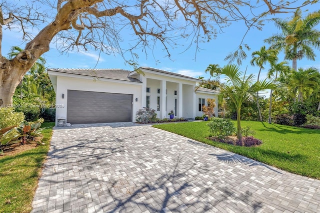 4440 NE 15th Ter, Oakland Park, FL 33334 - view of front of house featuring stucco siding, an attached garage, a front lawn, and decorative driveway