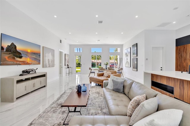 living area with visible vents, recessed lighting, marble finish floor, and baseboards