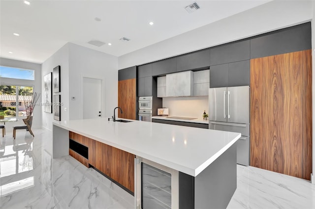 kitchen featuring visible vents, marble finish floor, modern cabinets, and freestanding refrigerator