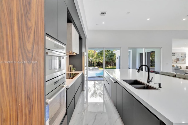 kitchen featuring visible vents, a sink, light countertops, modern cabinets, and marble finish floor