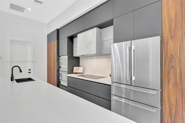 kitchen with a sink, stainless steel appliances, visible vents, and gray cabinetry