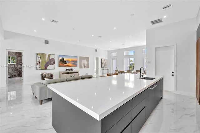 kitchen with visible vents, modern cabinets, marble finish floor, and a sink