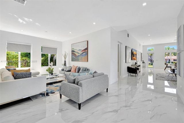 living area with recessed lighting, visible vents, and marble finish floor