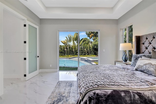 bedroom featuring multiple windows, a tray ceiling, baseboards, and access to outside