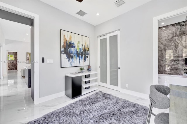 living area featuring visible vents, baseboards, and marble finish floor