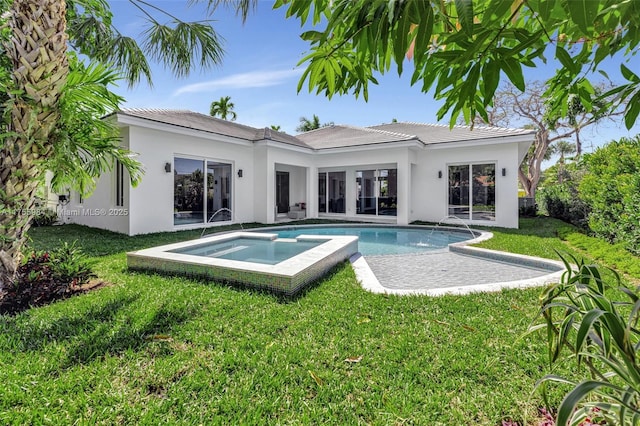 back of property with an outdoor pool, stucco siding, an in ground hot tub, and a yard