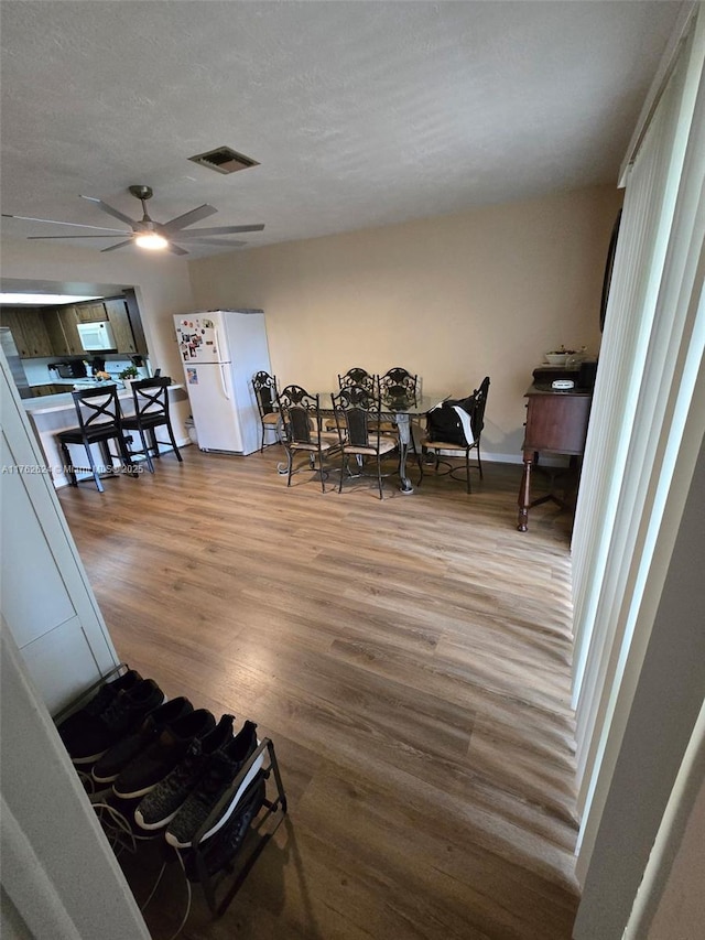 dining room featuring wood finished floors, visible vents, and a textured ceiling