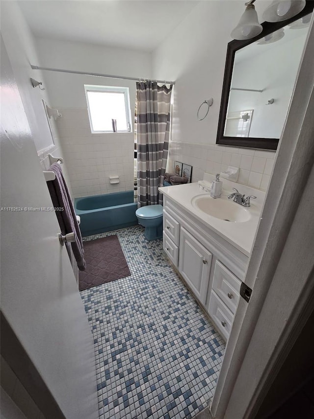 full bathroom featuring toilet, shower / bath combo, tile walls, tile patterned flooring, and vanity