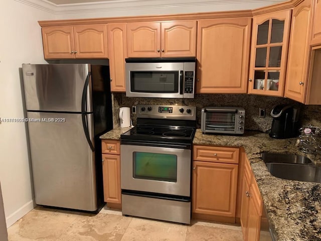 kitchen with glass insert cabinets, a toaster, decorative backsplash, stainless steel appliances, and a sink