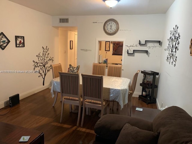 dining area featuring dark wood finished floors, visible vents, and baseboards