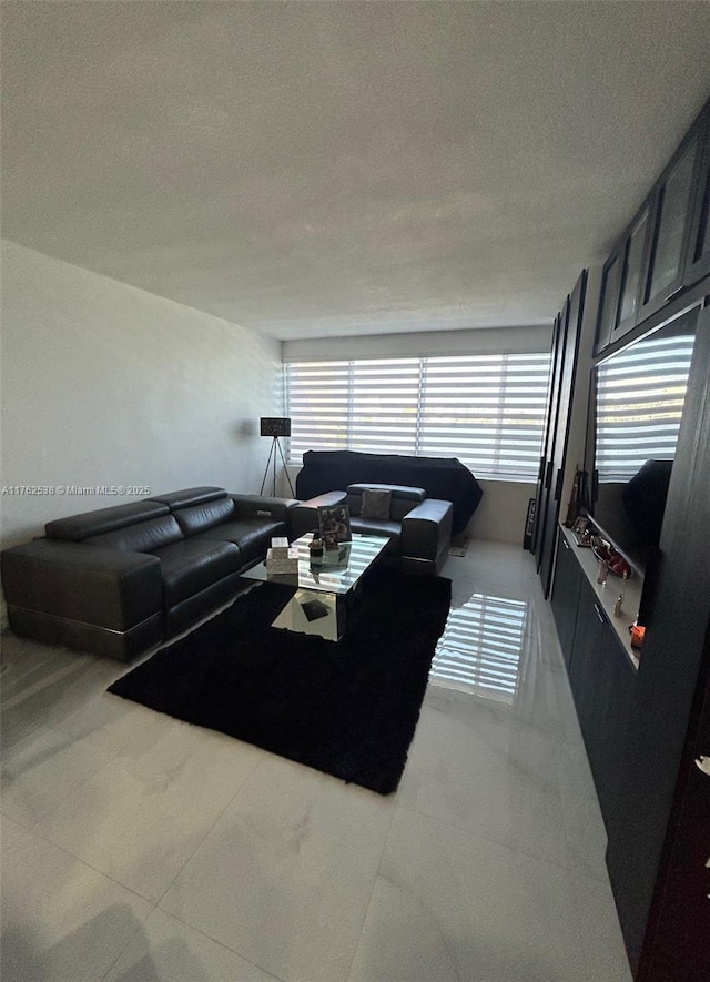 living area featuring light tile patterned floors and a textured ceiling