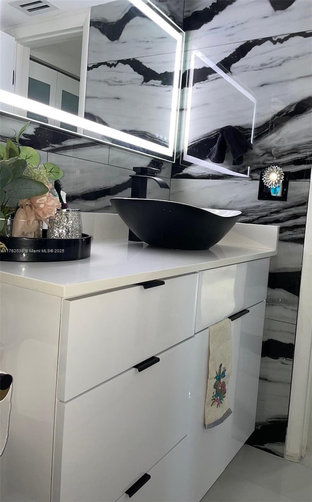 18555 NE 14th Ave Unit 609, Miami, FL 33179 - interior details with visible vents, decorative backsplash, and vanity