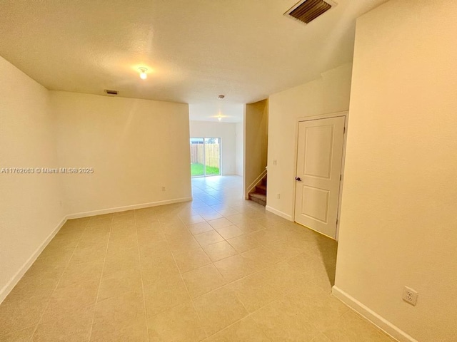 spare room with visible vents, baseboards, and stairs