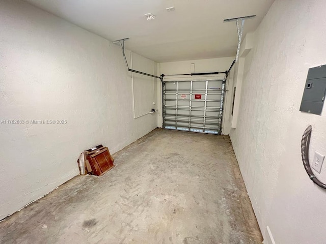 garage featuring electric panel and a textured wall