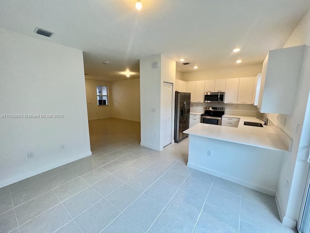 kitchen with visible vents, light countertops, white cabinets, stainless steel appliances, and a sink