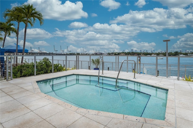 view of swimming pool with a water view and a patio