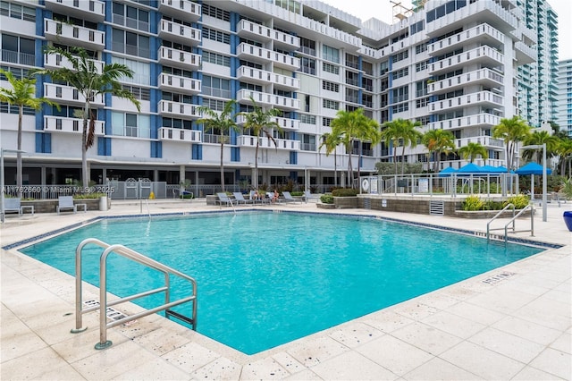 community pool featuring a patio area and fence