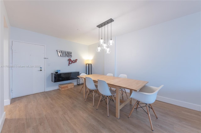 dining area with baseboards and light wood-type flooring