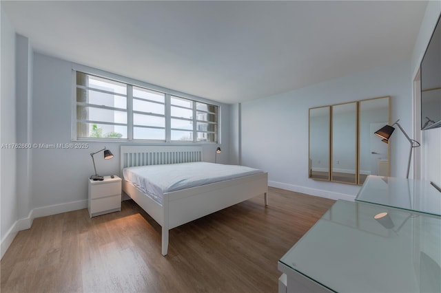 bedroom with baseboards and light wood finished floors