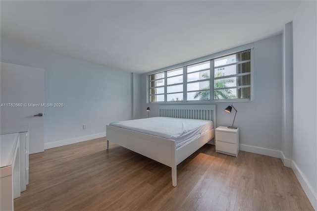 bedroom featuring baseboards and wood finished floors