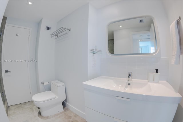 bathroom featuring visible vents, backsplash, toilet, and vanity