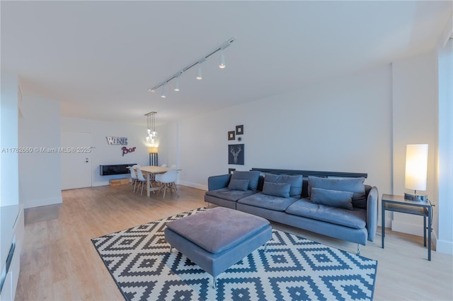 living room featuring track lighting, light wood-type flooring, and baseboards