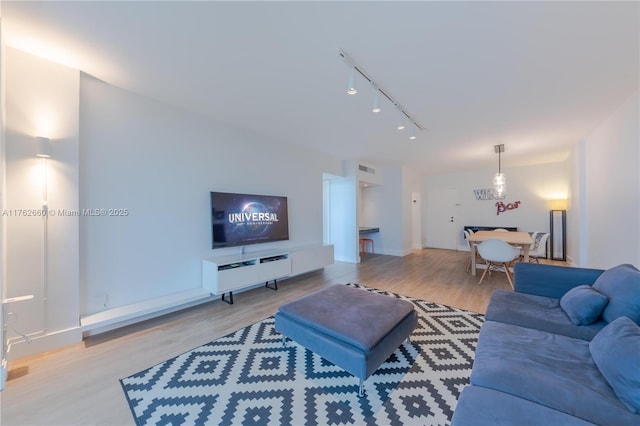 living room featuring visible vents, rail lighting, and wood finished floors