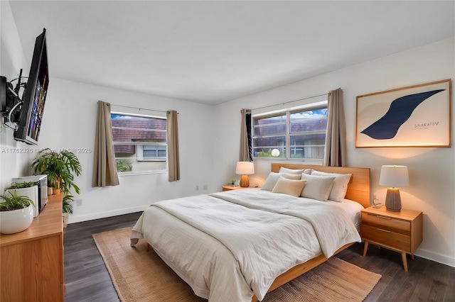 bedroom with baseboards and dark wood-style flooring