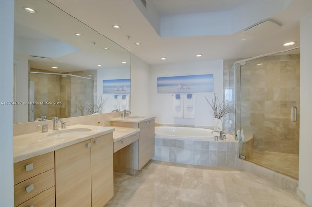 bathroom with two vanities, recessed lighting, a stall shower, a sink, and a bath