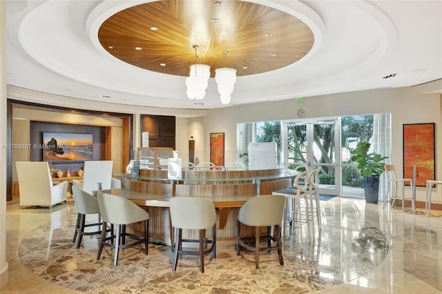 interior space with marble finish floor, decorative light fixtures, recessed lighting, an inviting chandelier, and a raised ceiling