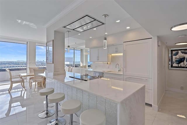 kitchen with a sink, black electric stovetop, a wealth of natural light, and white cabinetry