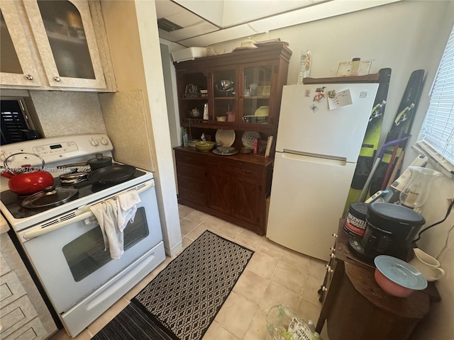 kitchen featuring light tile patterned floors, decorative backsplash, white appliances, and glass insert cabinets