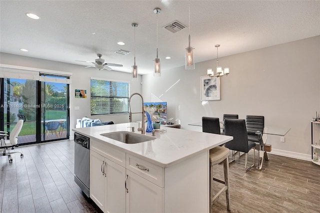 kitchen with visible vents, dishwasher, wood tiled floor, and a sink